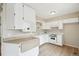 Bright kitchen featuring white cabinets and appliances, complemented by hardwood floors and light countertops at 12885 W Alameda Dr, Lakewood, CO 80228