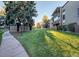 Building exterior shows large grassy area with mature trees and walkway at 2281 S Vaughn Way # 118A, Aurora, CO 80014