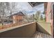Cozy balcony view showcasing a charming brick building and a serene outdoor setting with mature trees and green space at 3050 W 32Nd Ave # 102C, Denver, CO 80211