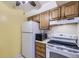 A kitchen featuring white appliances, wooden cabinets and a ceiling fan at 3050 W 32Nd Ave # 102C, Denver, CO 80211