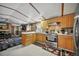Well-lit kitchen with stainless steel appliances and wood cabinets, open to living area at 422 Willow Dr, Lochbuie, CO 80603