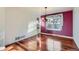 Dining room features hardwood floors, purple accent wall, and chandelier above a window at 17045 Hastings Ave, Parker, CO 80134