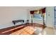 Living room showcasing hardwood floors, a bay window with curtains, and tiled entry at 17045 Hastings Ave, Parker, CO 80134