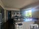 Well lit kitchen with stainless appliances, large island, updated countertops, and dark wood floors at 3811 Lisbon Ct, Denver, CO 80249