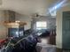 Cozy living room featuring a stone fireplace, beamed mantel, wood floors, and a ceiling fan at 3811 Lisbon Ct, Denver, CO 80249