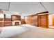 Cozy basement area with wood paneling, fireplace and built-in cabinets; a warm and inviting space at 3444 S Bellaire St, Denver, CO 80222