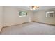 Spacious bedroom with neutral carpet, ceiling fan, and natural light from two windows at 3444 S Bellaire St, Denver, CO 80222