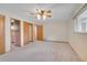 Bedroom showing carpet, ceiling fan, closet doors, and doorway to the pink bathroom at 3444 S Bellaire St, Denver, CO 80222