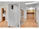 Hallway with hardwood floors and a staircase leads to a skylight and additional storage at 3444 S Bellaire St, Denver, CO 80222