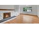 Bright living room showcases hardwood floors, a white stone fireplace, and a large picture window at 3444 S Bellaire St, Denver, CO 80222