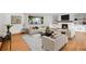 Bright living room showcases hardwood floors, a white stone fireplace, large picture window, and comfortable seating at 3444 S Bellaire St, Denver, CO 80222