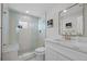 Renovated bathroom featuring subway tile shower with glass, marble floors, gold fixtures and white vanity at 18866 W 59Th Pl, Golden, CO 80403