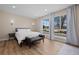 Inviting bedroom with ample natural light, wood floors, bench and modern sconces at 18866 W 59Th Pl, Golden, CO 80403