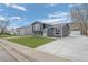 Gray single-Gathering home with updated siding, a well-manicured lawn and a long driveway to the detached garage at 18866 W 59Th Pl, Golden, CO 80403