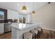 Bright kitchen with white cabinetry, island with seating, modern appliances and stylish pendant lighting at 18866 W 59Th Pl, Golden, CO 80403