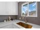 Modern kitchen features quartz countertops, a gold sink and cabinets with views of outside at 18866 W 59Th Pl, Golden, CO 80403