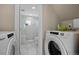 Bright laundry area with washer and dryer next to renovated bathroom with glass shower and marble floors at 18866 W 59Th Pl, Golden, CO 80403