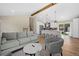 Open concept living room with wood beam, kitchen view, and neutral toned contemporary furniture at 18866 W 59Th Pl, Golden, CO 80403