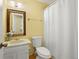 Bathroom features a vanity with marble countertop, framed mirror, toilet and shower with white curtain at 2608 E Fremont Pl, Centennial, CO 80122