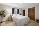 Bedroom features a large bed, wooden closet, carpeted floors, neutral paint and bright light at 2608 E Fremont Pl, Centennial, CO 80122