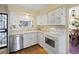 Cozy kitchen featuring white cabinets, stainless steel dishwasher, and wood floors at 2608 E Fremont Pl, Centennial, CO 80122