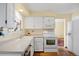 Bright kitchen featuring white cabinets, white appliances and wood floors at 2608 E Fremont Pl, Centennial, CO 80122