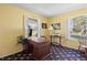 Office space with a wooden desk, bookshelf, and two windows at 2608 E Fremont Pl, Centennial, CO 80122