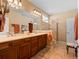 Bathroom featuring a double vanity, large mirror, walk-in shower, and neutral tiling at 19795 W 57Th Ave, Golden, CO 80403