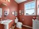 Charming powder room with a pedestal sink, decorative mirror, and natural light from the window at 19795 W 57Th Ave, Golden, CO 80403