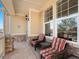 Inviting covered front porch with stone columns, seating area, and beautiful natural light from the windows at 19795 W 57Th Ave, Golden, CO 80403