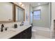 Modern bathroom showcasing double sinks, wood-framed mirrors, and a tub with black fixtures at 853 Saint Paul St, Denver, CO 80206