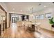 Bright dining room with modern light fixture, light wood floors and open concept to the kitchen at 853 Saint Paul St, Denver, CO 80206
