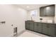 Modern laundry room features stylish cabinets, sink, countertops, and gray flooring at 853 Saint Paul St, Denver, CO 80206