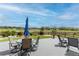 Outdoor dining on the back patio with a table, chairs, umbrella, and backyard views, perfect for al fresco meals at 11890 Discovery Cir, Parker, CO 80138