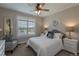 Cozy bedroom with a large window, shutters, neutral walls, and ceiling fan at 11890 Discovery Cir, Parker, CO 80138