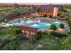 Aerial view of a luxurious community pool and recreational area with a backdrop of houses and colorful sunset at 11890 Discovery Cir, Parker, CO 80138