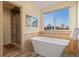 Bright bathroom featuring a freestanding tub, wood paneling and a glass-enclosed shower at 4530 Ridgewood Ct, Castle Rock, CO 80109