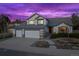 Charming two-story home with a three-car garage, manicured landscaping, and a cozy front porch at twilight at 4530 Ridgewood Ct, Castle Rock, CO 80109