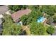Aerial view of a home nestled among mature trees, featuring a backyard pool and patio area at 8130 E Bethany Pl, Denver, CO 80231