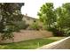 A brick retaining wall accents the backyard and the mature trees surrounding the property at 8130 E Bethany Pl, Denver, CO 80231