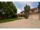 Traditional two-story home with a covered front porch, attached garage, and expansive driveway at 8130 E Bethany Pl, Denver, CO 80231