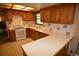 View of the kitchen with white countertops, wood cabinets, and white appliances at 8130 E Bethany Pl, Denver, CO 80231