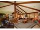 Spacious living room featuring a high ceiling with exposed beams and an open layout to the dining area at 8130 E Bethany Pl, Denver, CO 80231