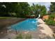 Sparkling in-ground pool with slide, surrounded by a concrete patio and privacy fence at 8130 E Bethany Pl, Denver, CO 80231