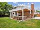 Backyard with covered patio, brick chimney, and well-maintained lawn at 13225 Peacock Dr, Lone Tree, CO 80124