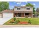 Charming two-story home featuring manicured front yard, brick facade, and covered porch with seating area at 13225 Peacock Dr, Lone Tree, CO 80124