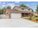 Inviting two-story home with brick and siding, large garage and driveway, and well-kept lawn with garden at 13225 Peacock Dr, Lone Tree, CO 80124
