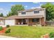 Charming two-story home featuring manicured front yard, brick facade, and covered porch with American flag at 13225 Peacock Dr, Lone Tree, CO 80124