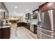 Spacious kitchen with stainless steel appliances, dark wood cabinets and adjoining living room at 13225 Peacock Dr, Lone Tree, CO 80124