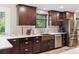 Modern kitchen featuring dark wood cabinets, stainless steel appliances, quartz countertop, and a breakfast bar at 13225 Peacock Dr, Lone Tree, CO 80124